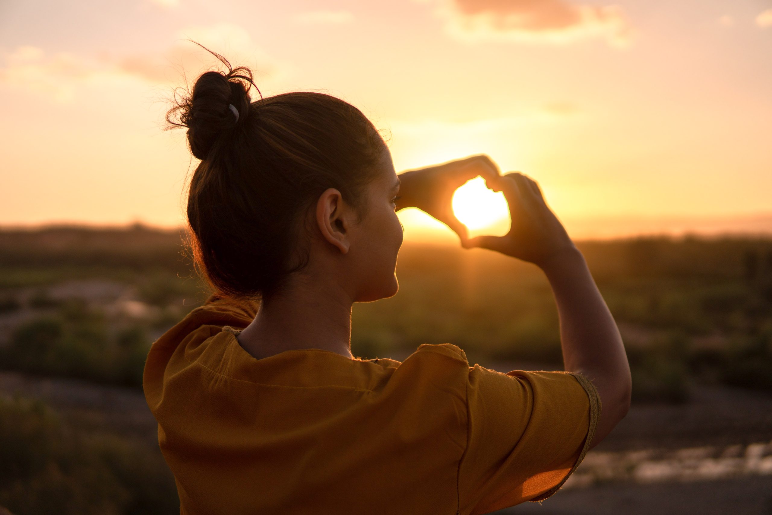 Person sitting outdoors at sunset